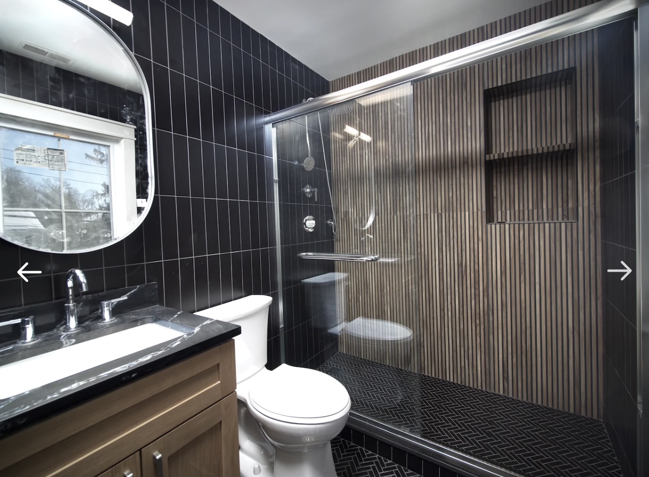 Primary bathroom with dark tile and wood slat shower
